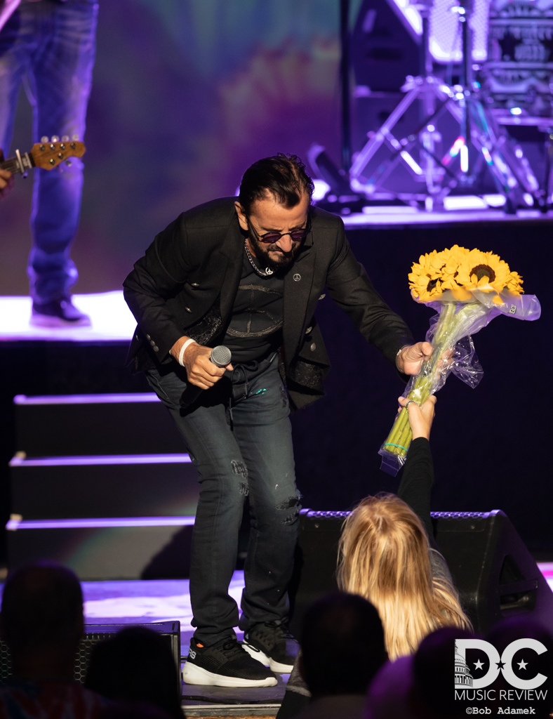 Ringo Starr accepting flowers from a member of the audience