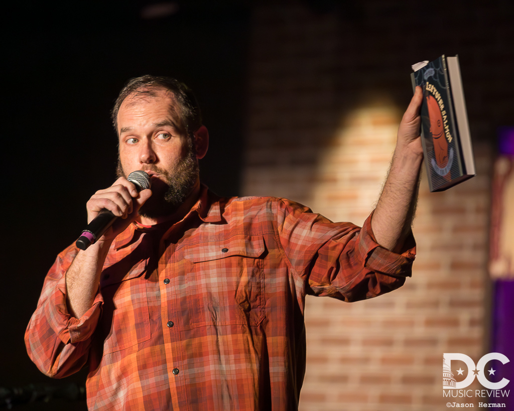 Tim Newby, reading from "Leftover Salmon: Thirty Years of Festival!" at Drew Emmitt & Vince Herman's Washington City Winery performance in February 2020