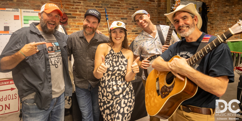 The band posing backstage with Tim Newby before their performance